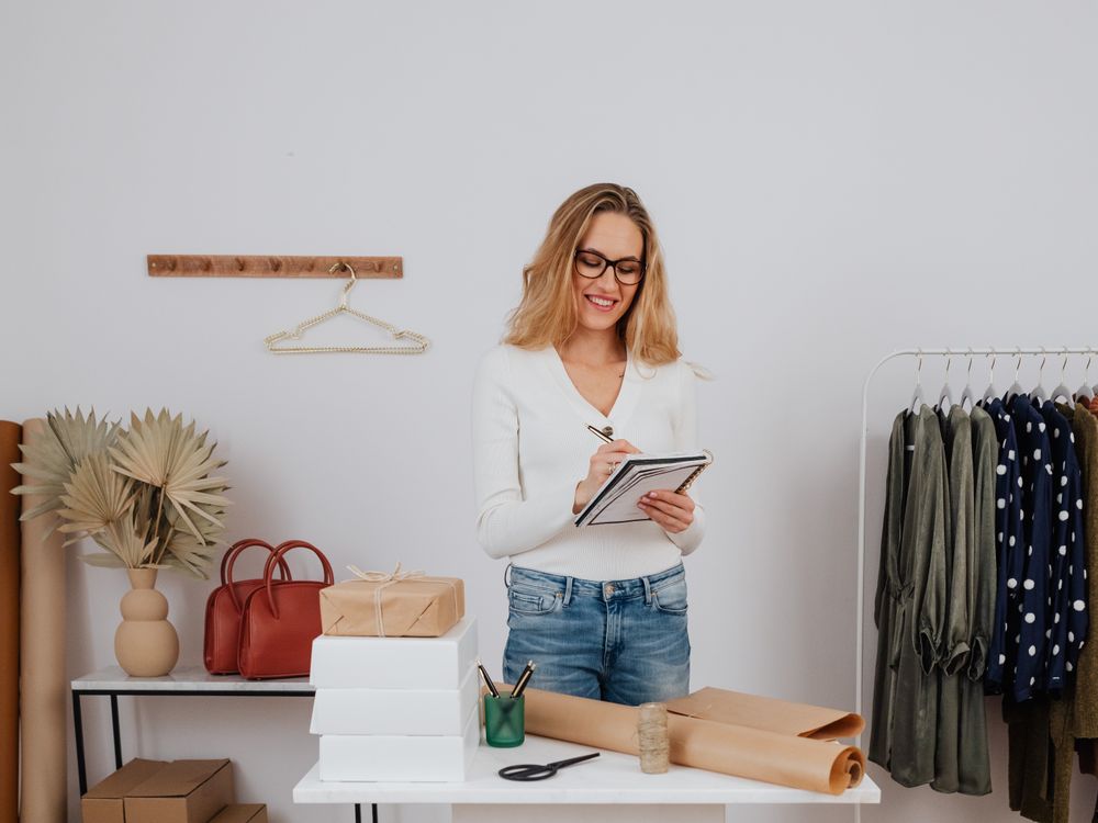 Dona da boutique organizando as peças na loja